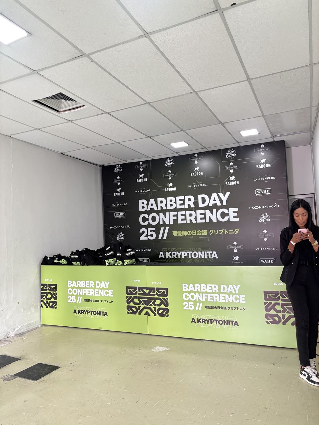 Bastidores de montagem de backdrop cenográfico com materiais empilhados em evento corporativo