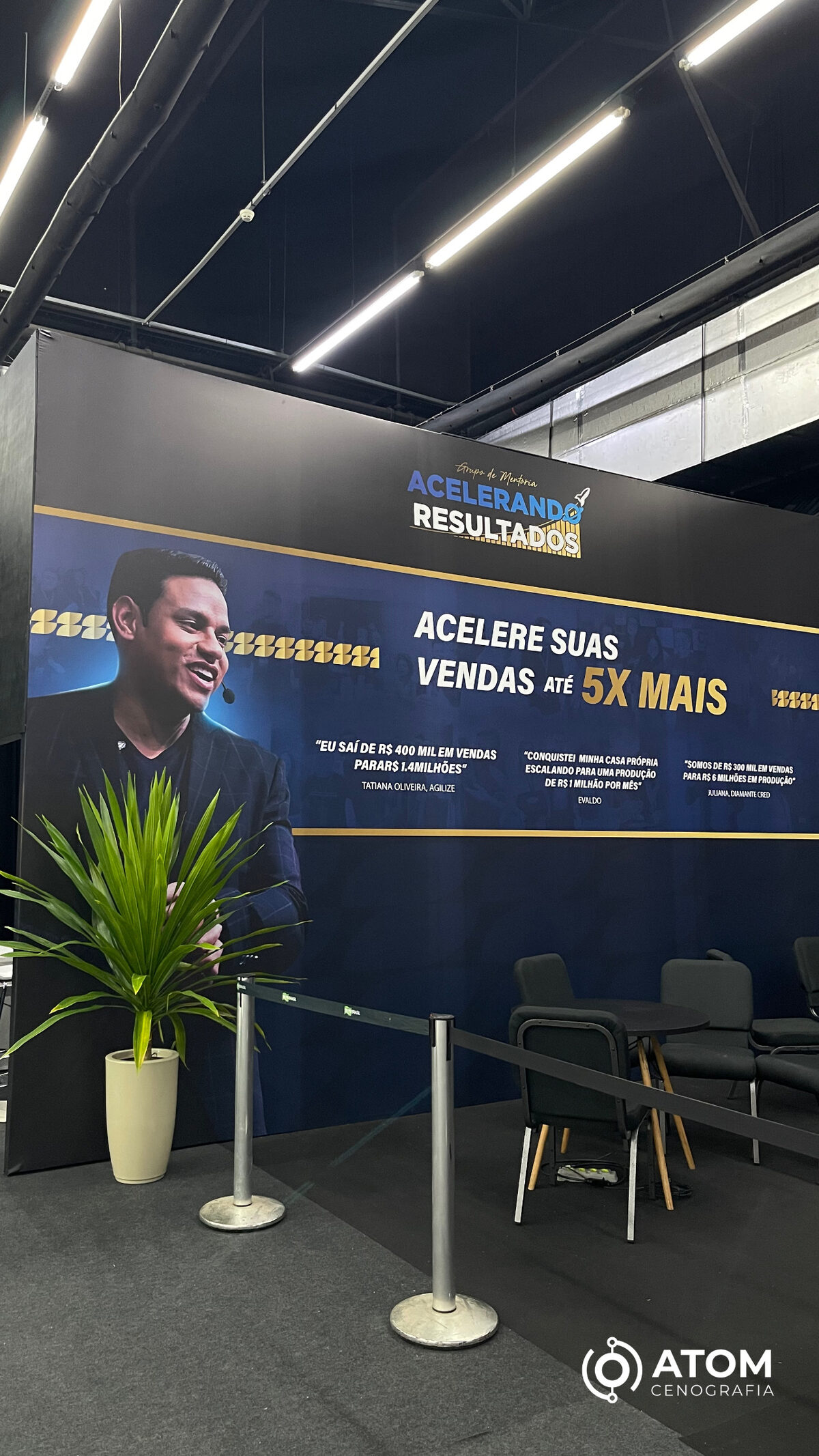 Backdrop cenográfico com assentos e área de descanso em evento — a circulação ampla convida à permanência