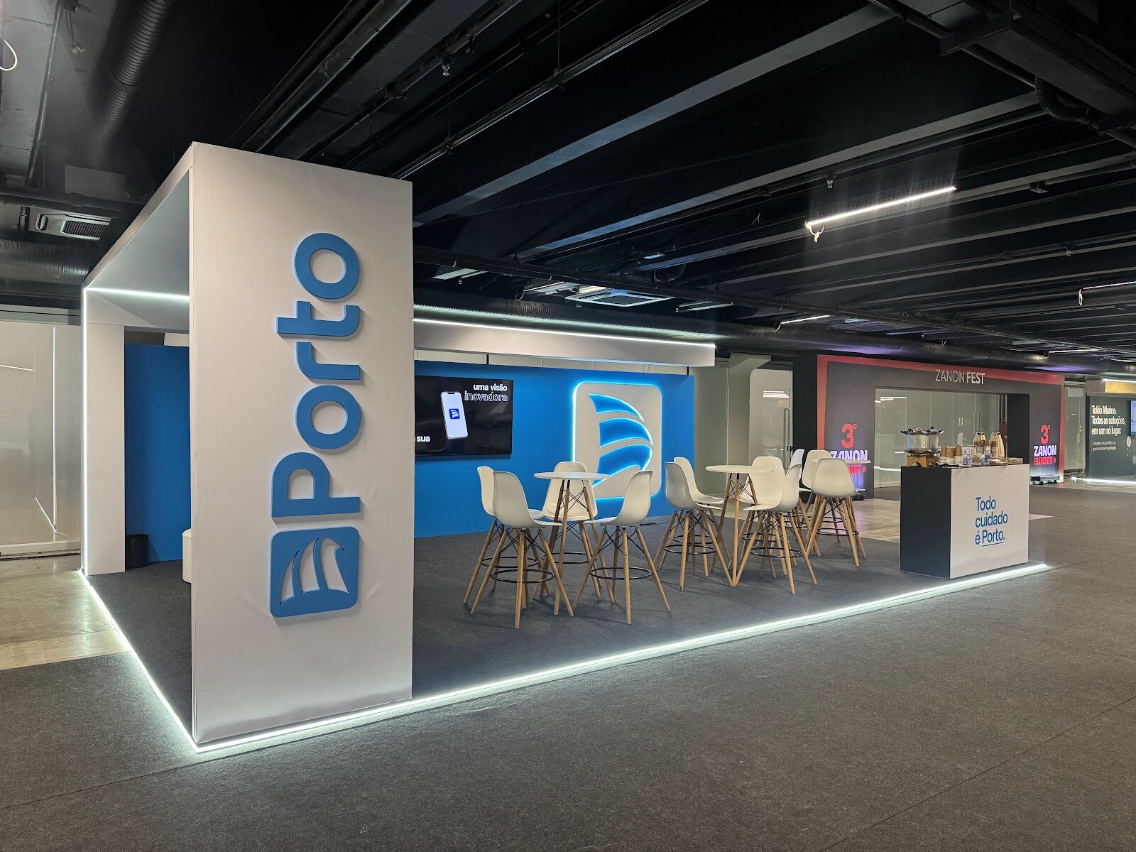 Estande corporativo com painel azul iluminado e logotipo em relevo na feira