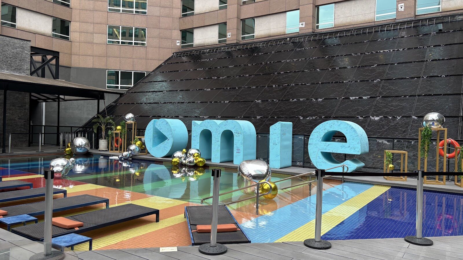 Letras cenográficas gigantes à beira de piscina em evento corporativo ao ar livre