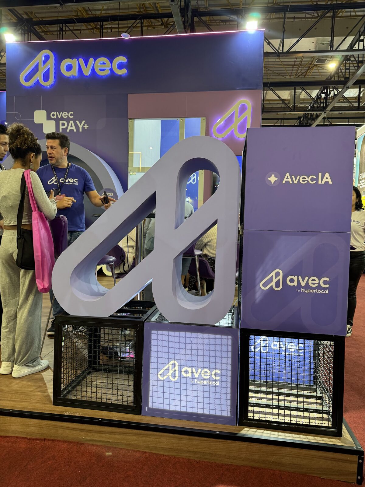 Detalhe de logotipo tridimensional e estrutura cenográfica no stand Avec em feira de beleza