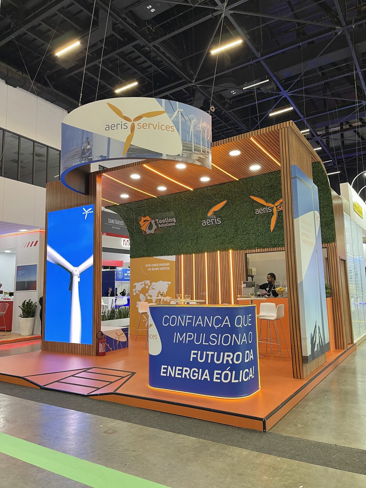 Stand Aeris Service em feira com testeira iluminada e madeira ripada no balcão
