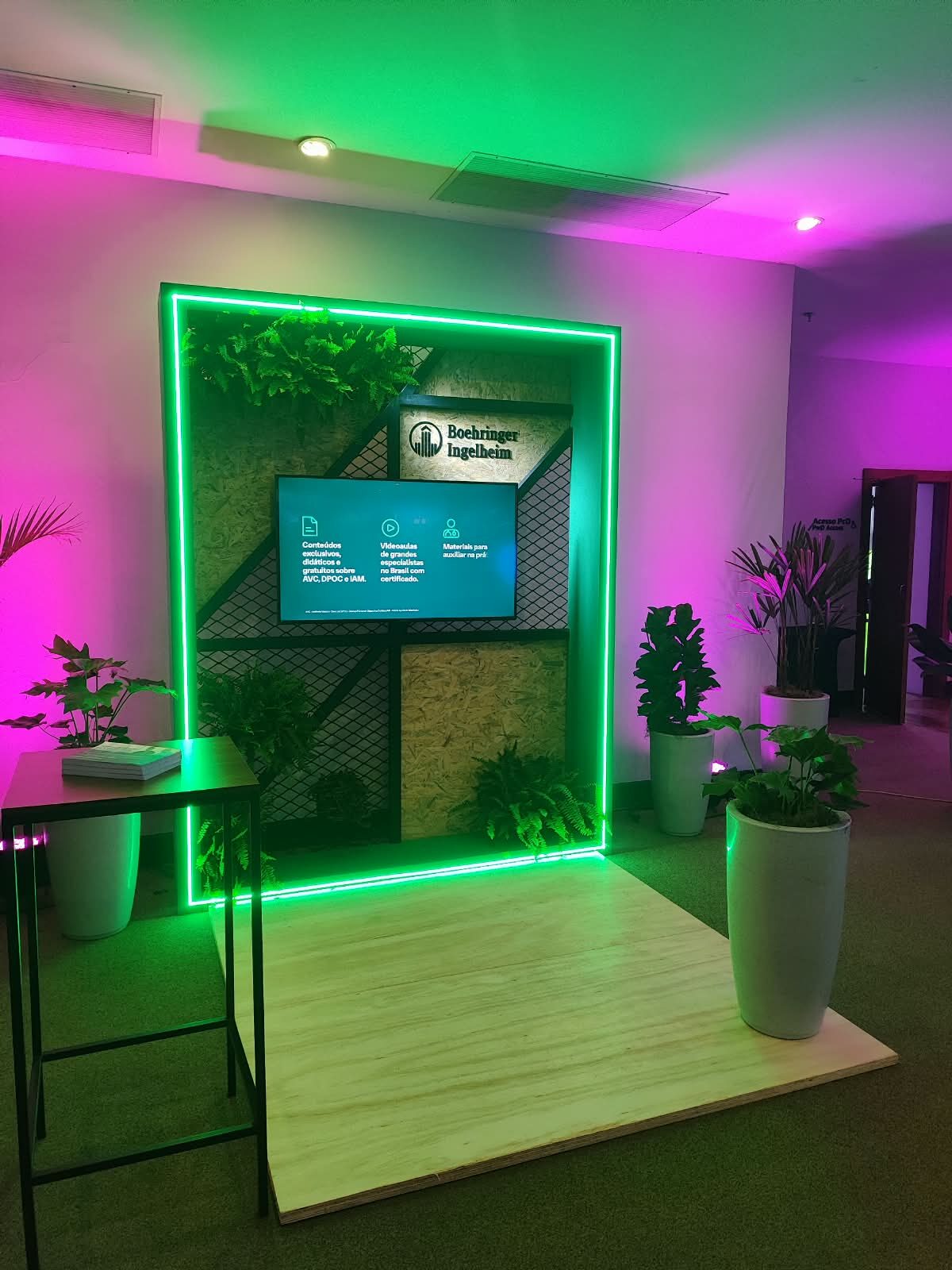 Painel de jardim vertical com friso de LED verde, tela institucional e logotipo Boehringer Ingelheim em ativação de feira