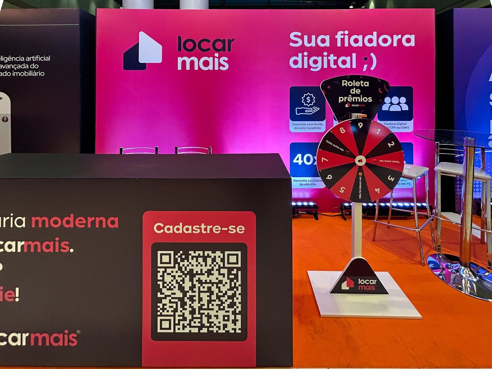 Stand construído com roleta interativa e sinalização em feira corporativa, acabamento impecável