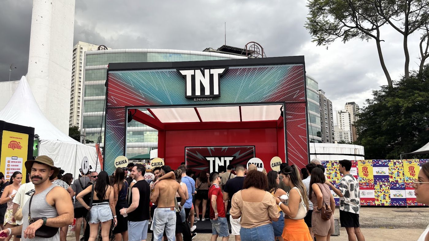 Fachada cenográfica temática de estande TNT Energy em estilo quadrinho com fila de visitantes