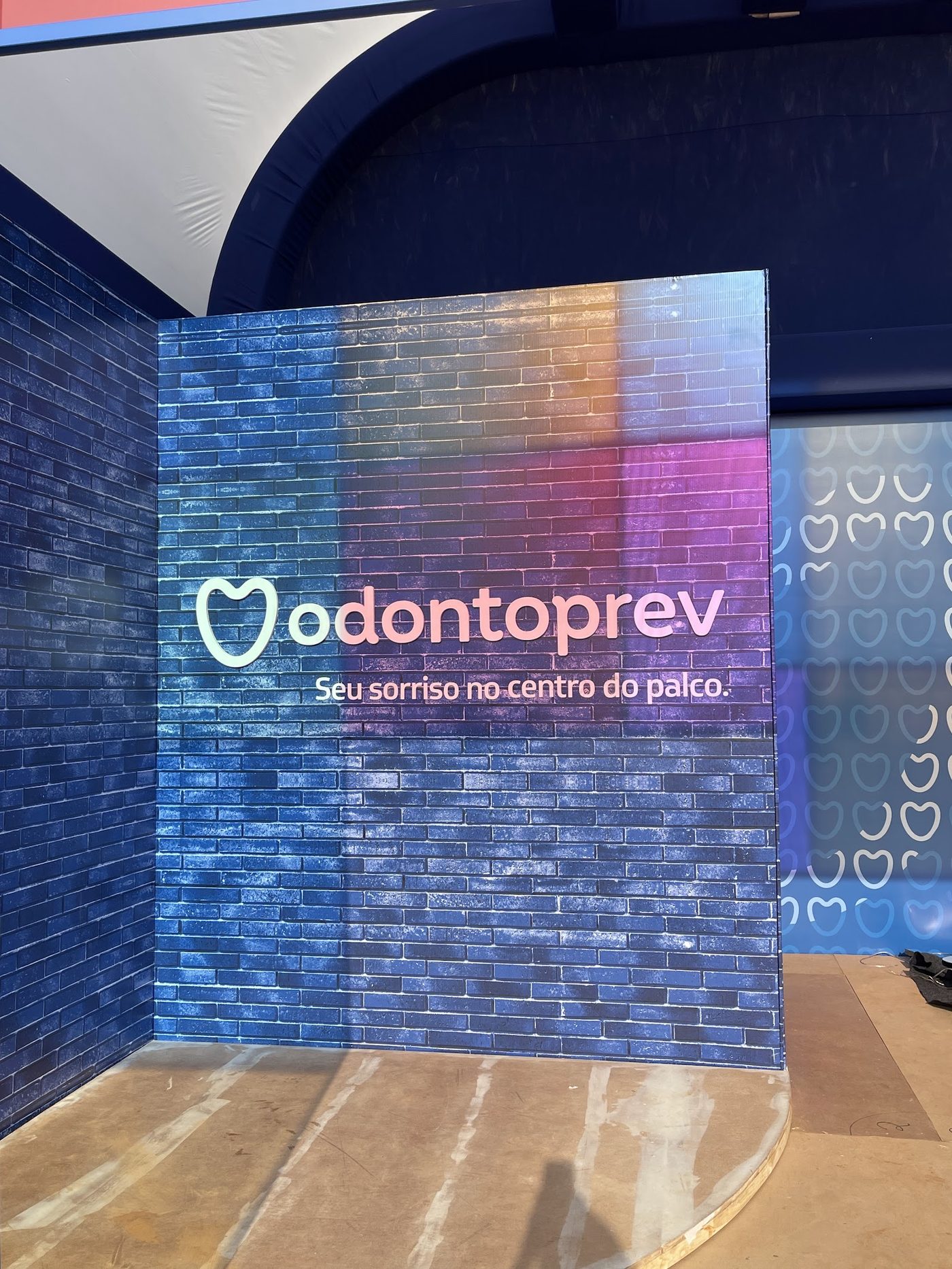 Painel cenográfico de tijolos coloridos com logo Odontoprev em montagem no Festival Nômade