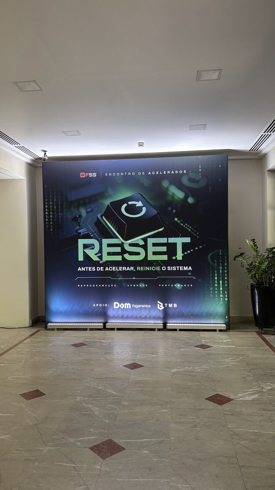 Backdrop cenográfico em tons azuis com iluminação decorativa em evento corporativo