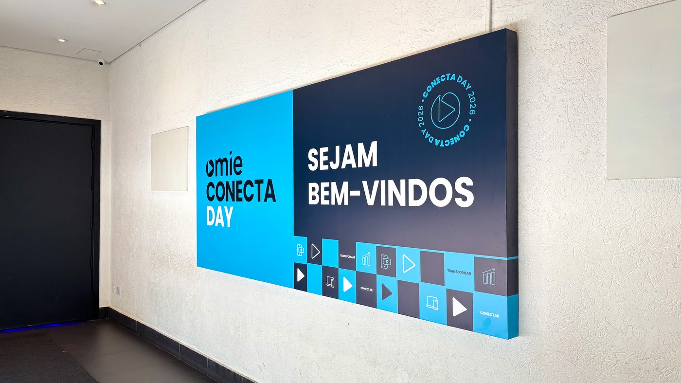 Placa em PS adesivada aplicada na entrada do Espaço Unimed com identidade visual Omie