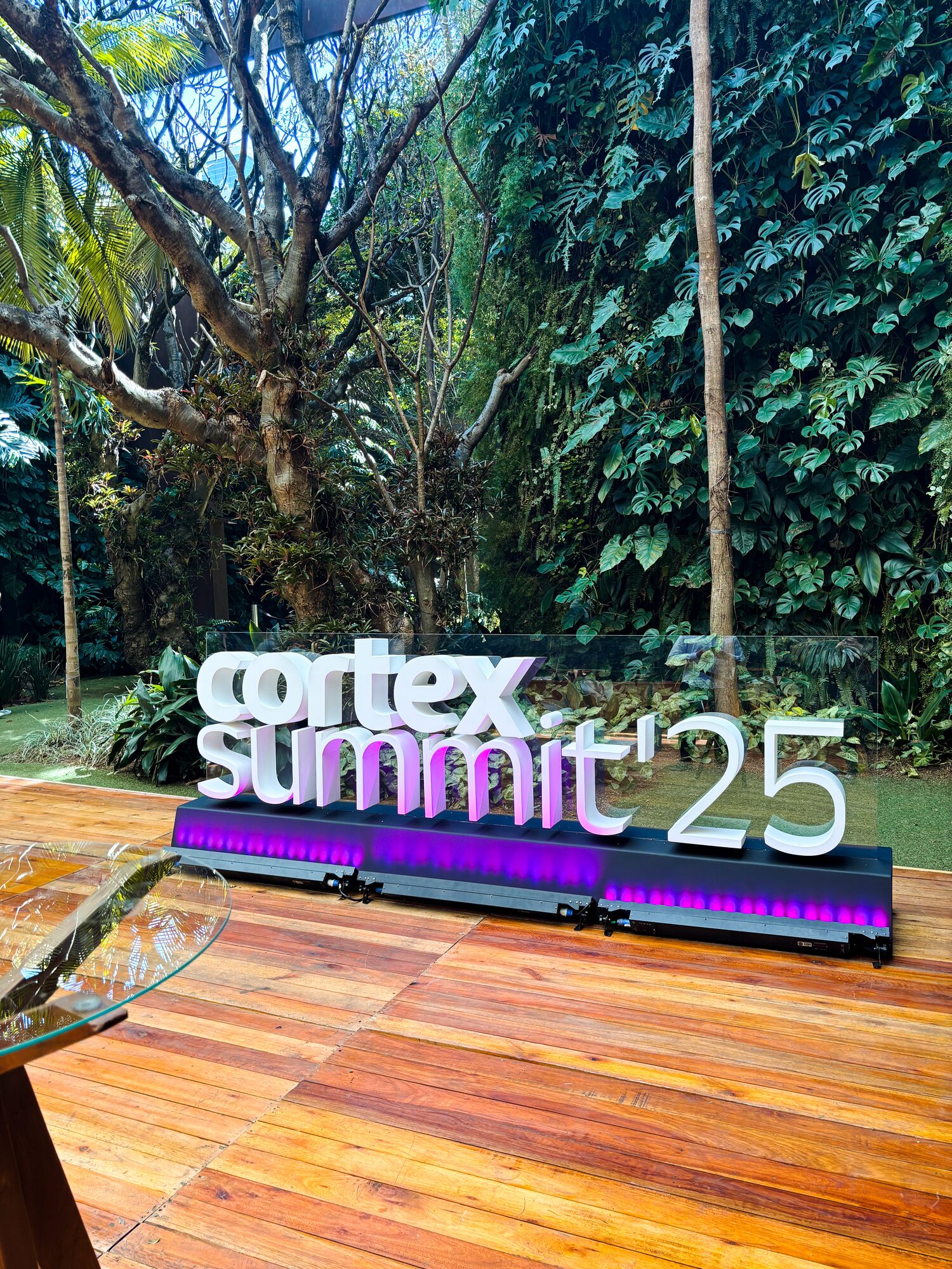 Letreiro 3D Cortex Summit 25 em letra caixa sobre painel de vidro