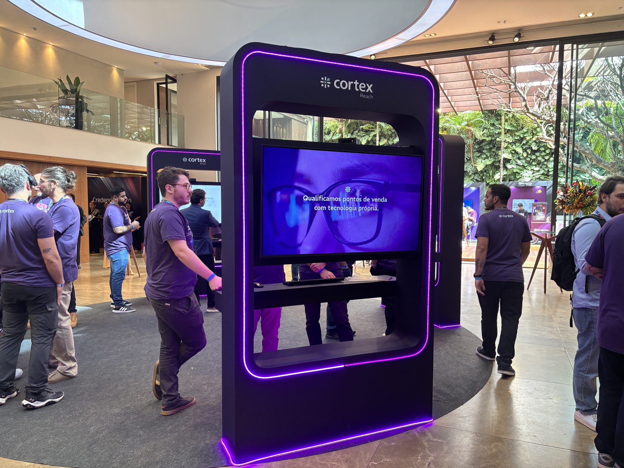Totem de demonstração com TV e LED roxo embutido projetado pela Atom para o Cortex Summit 2025