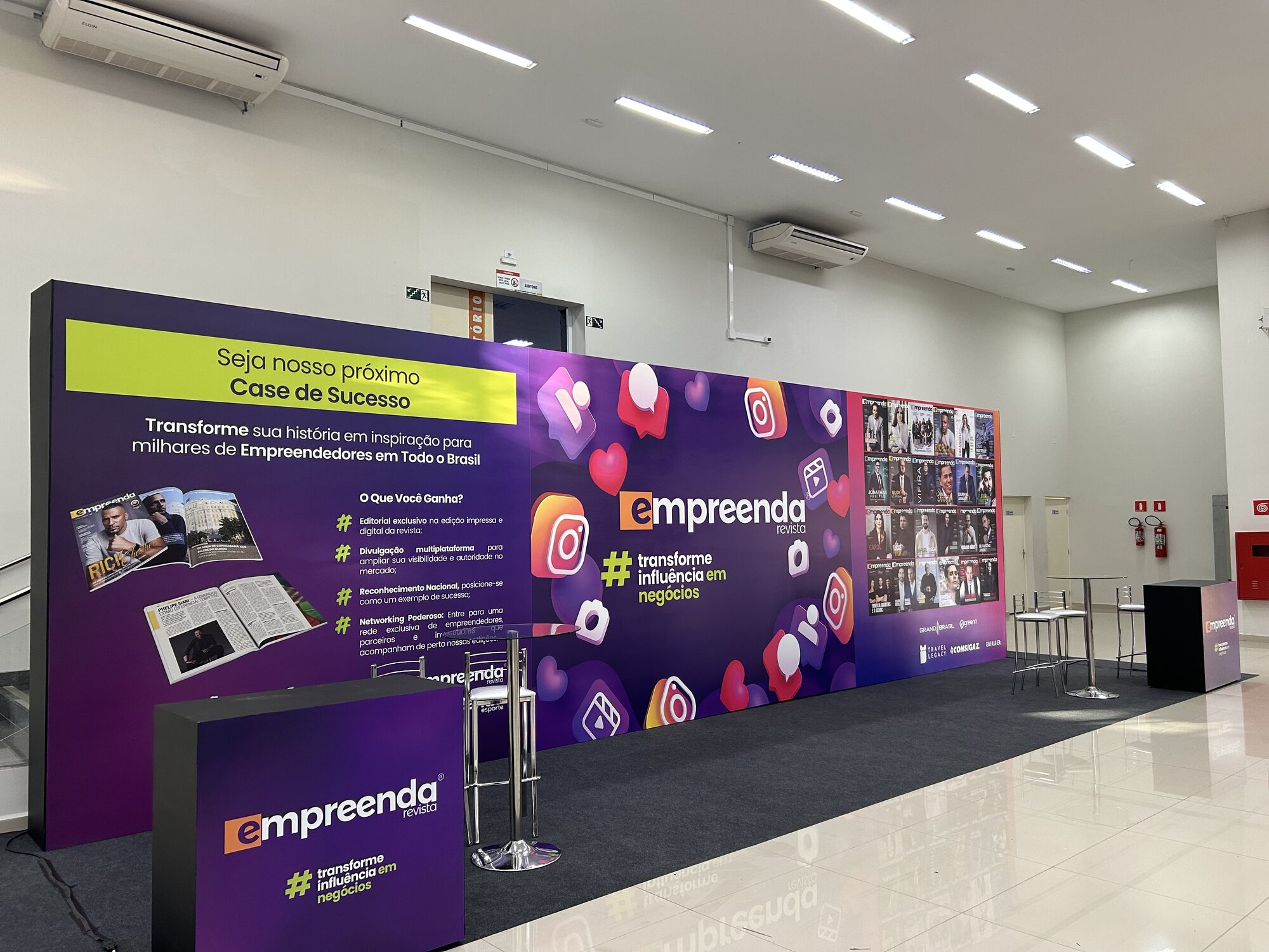 Área de convivência de 3x3m com backdrop e mobiliário de apoio para o Empreenda Summit 2025