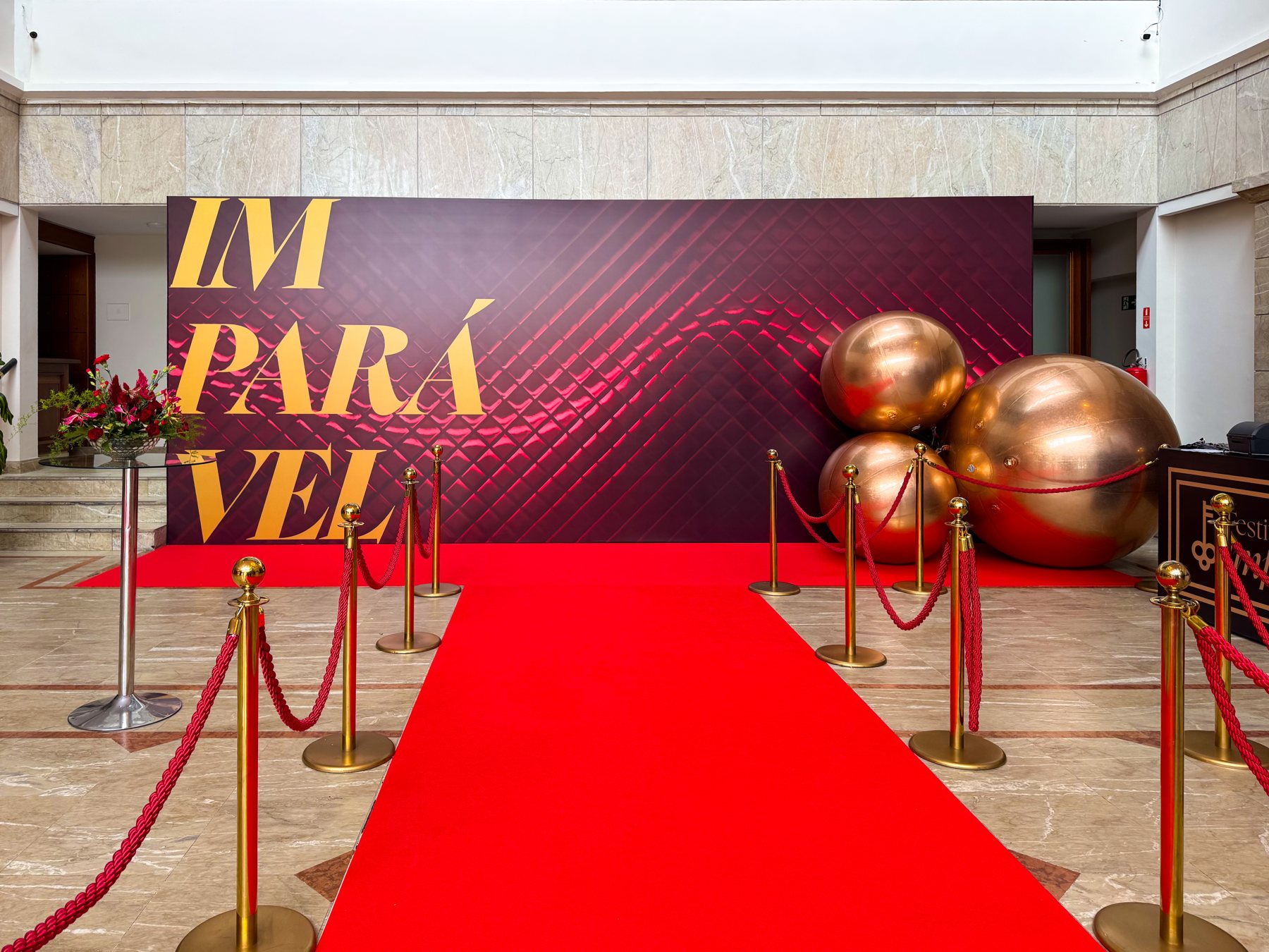 Ponto de fotos IMPARÁVEL de 7,45 m em capitonê vermelho com letras douradas e tapete vermelho, cenografia da Atom Cenografia no Festival das Imparáveis